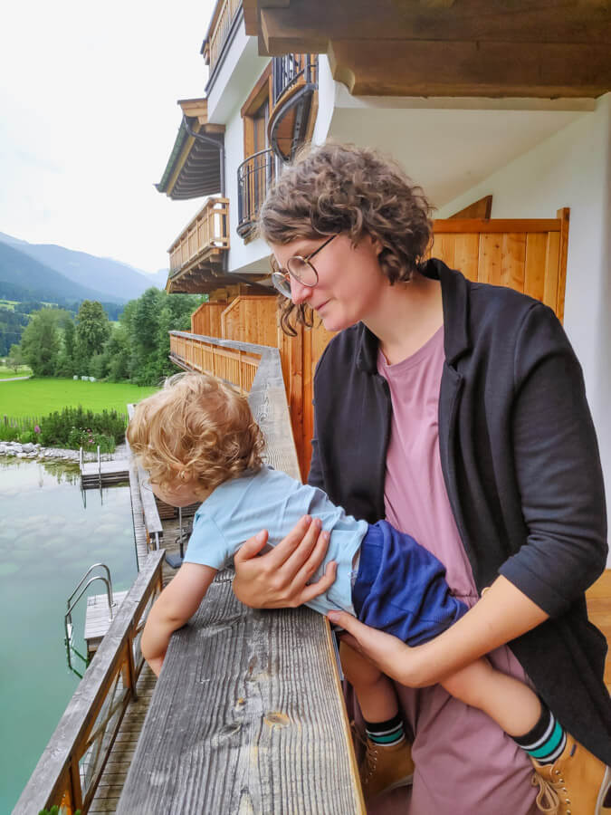 Familienfotografin Alicia Leopold hält ihren Sohn im Arm und schaut mit ihm gemeinsam über den Balkon