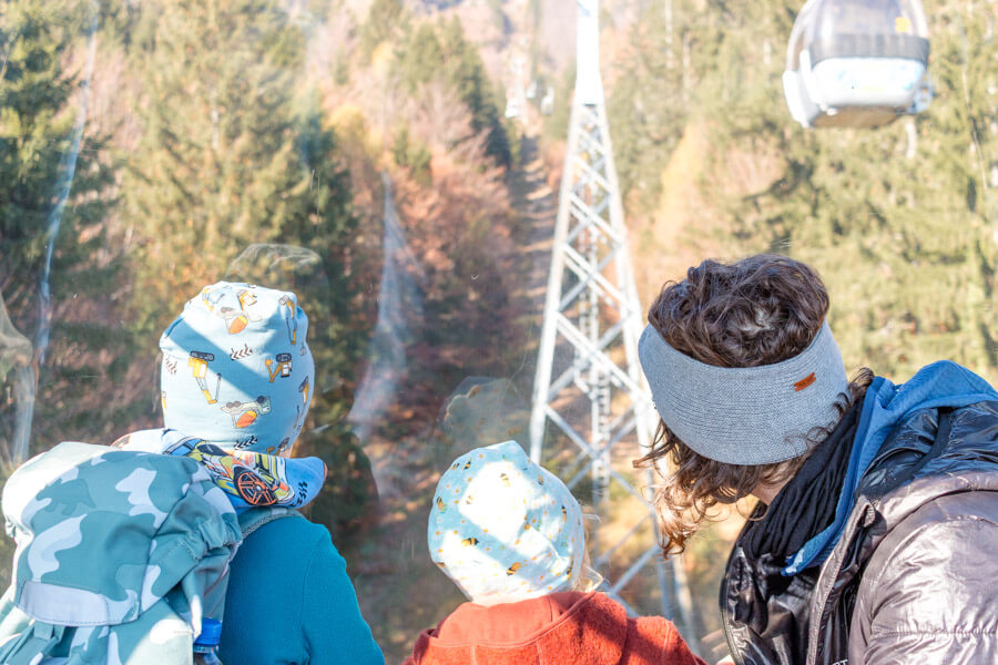 Familienfotografin von Alicia fotografiert sitzt mit Kindern in einer Gondel beim gemeinsamen Familienausflug