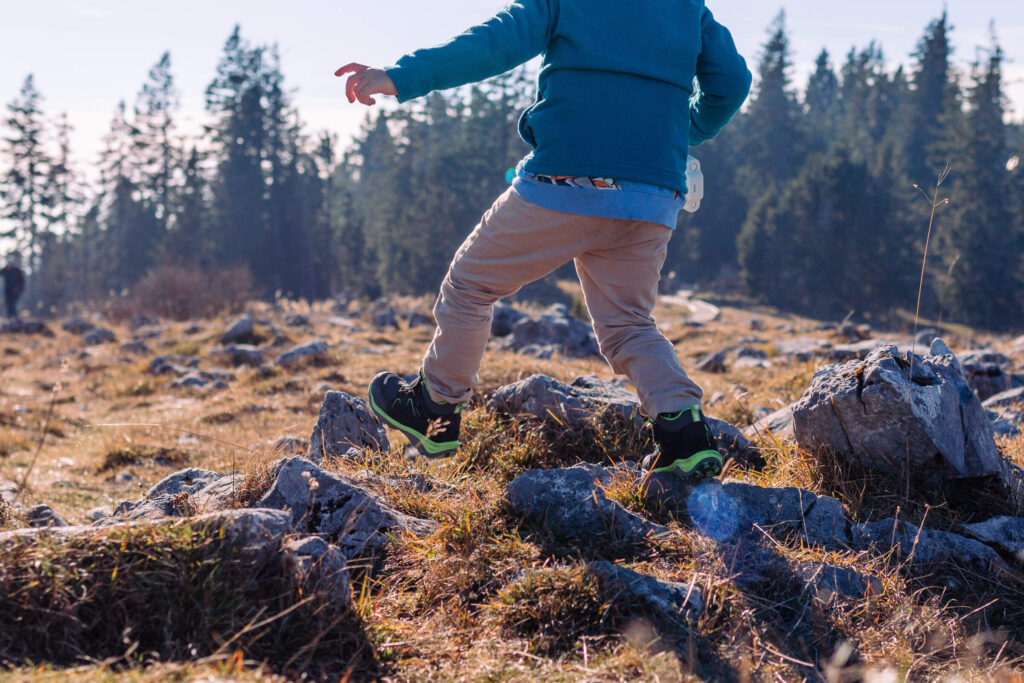 Kind beim Familienausflug nahe Graz beim Wandern durch felsige Landschaft