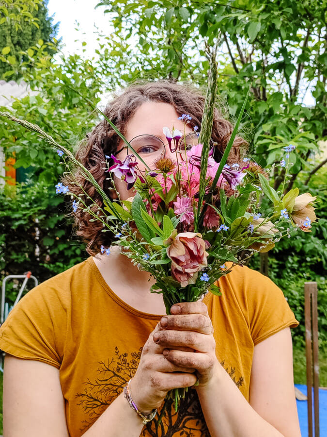 Ich, eure Familienfotografin aus Graz, mit selbst gepflückten Blumen – erdig, herzlich, echt.
